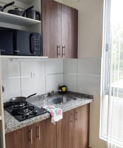 a kitchen with a sink and a stove top oven at Disfruta Cala-Cala in Cochabamba