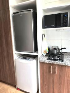 a kitchen with a refrigerator and a microwave and a stove at Disfruta Cala-Cala in Cochabamba