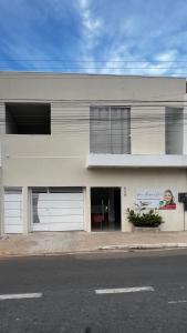 a white building with two garage doors on a street at Studio no Centro da Cidade in Parauapebas