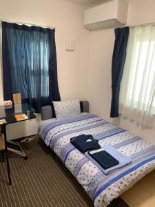 a bedroom with a bed with a desk and a window at Bessalov Home 1st room friendly house in Tokyo