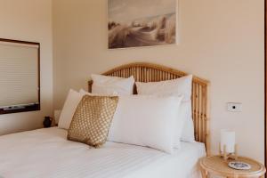 a bedroom with a bed with white sheets and pillows at Miramar Beach House in Seymour