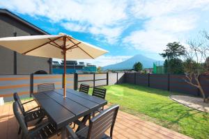 a table with an umbrella on a deck at Fuji Gran Villa - TOKI - in Fujiyoshida