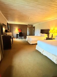 a hotel room with two beds and a desk at Riverview Lodge in Dryden