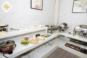 a buffet line with dishes and food on shelves at Hoa Hồng Hotel 2 - Xã Đàn in Hanoi