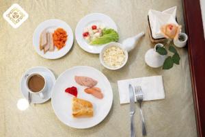 a table with plates of food and a cup of coffee at Hoa Hồng Hotel 2 - Xã Đàn in Hanoi