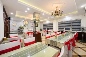 a restaurant with tables and chairs and a chandelier at Hoa Hồng Hotel 2 - Xã Đàn in Hanoi