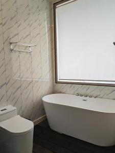 a bathroom with a white tub and a toilet at 微拉瓦丽 in Semporna