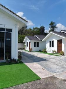a house with a green lawn in front of it at Aimers Lodge in Dungun