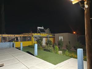 a yellow house with a yard at night at Luxfran in Uspallata