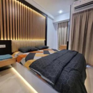 a bedroom with a large bed in a room at Delf Apartement Cpi Mewah By Selfiyani in Makassar +12 photos