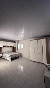 a large bedroom with a bed and white cabinets at Casa espaçosa e arejada in Garanhuns