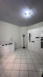 a large kitchen with white cabinets and a floor at Casa espaçosa e arejada in Garanhuns