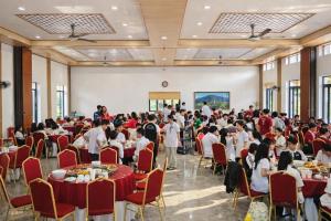 a crowd of people sitting at tables in a banquet hall at Kolia Resort in Cao Bằng