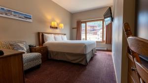 a hotel room with a bed and a chair at Cahilty #108 home in Sun Peaks