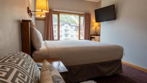 a hotel room with a large bed and a window at Cahilty #108 home in Sun Peaks