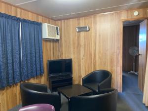 a room with a table and chairs and a television at Miners Rest Units in Mount Magnet