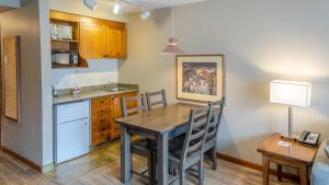 a kitchen with a wooden table and a dining room at Cahilty #214 home in Sun Peaks