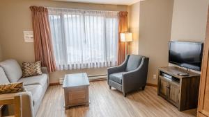 a living room with a couch and a television at Cahilty #214 home in Sun Peaks