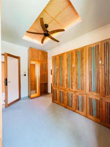 a room with wooden cabinets and a ceiling fan at Leafy Riverbank in Tabanan