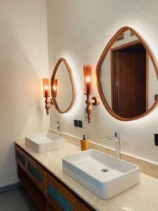 a bathroom with two sinks and a large mirror at Leafy Riverbank in Tabanan