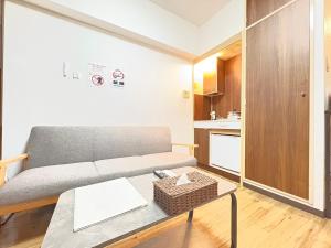 a living room with a couch and a table at サンシティ大濠公園 in Susakiuramachi