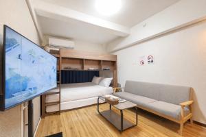 a living room with a couch and a large flat screen tv at サンシティ大濠公園 in Susakiuramachi