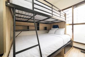 a bedroom with two bunk beds in a room at サンシティ大濠公園 in Susakiuramachi