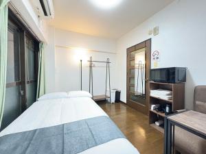 a hospital room with a bed and a tv at パルム天神西 in Susakiuramachi