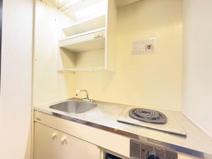 a small kitchen with a sink and a microwave at パルム天神西 in Susakiuramachi