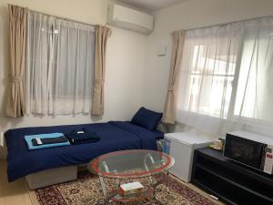 a small room with a bed and a glass table at Bessalov Home 2nd room friendly house in Tokyo