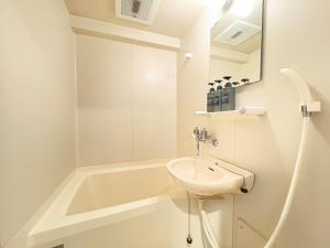 a white bathroom with a sink and a bath tub at パルム天神西 in Susakiuramachi +64 photos
