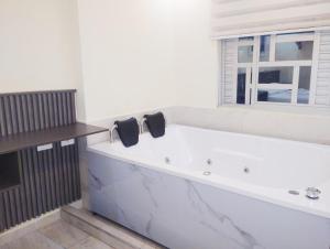 a large white bath tub in a room with a window at Hotel Magistral Suiter in Quibdó