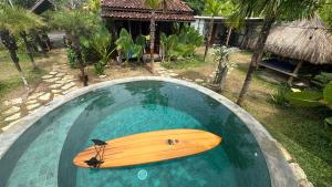 a wooden surfboard in a pool of water at Salty Siesta Stays in Selong Belanak +30 photos