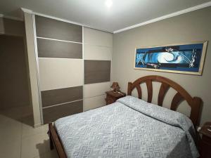 a small bedroom with a bed and a picture on the wall at Dos D Point "pleno centro" in Río Tercero