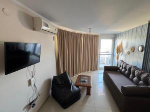 a living room with a couch and a flat screen tv at Dos D Point "pleno centro" in Río Tercero