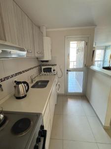 a kitchen with a stove and a sink and a window at Dos D Point "pleno centro" in Río Tercero