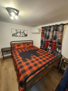 a bedroom with a bed with a checkered blanket at Serenity Cabin - Cozy Mountain retreat near Shenandoah National Park in Luray