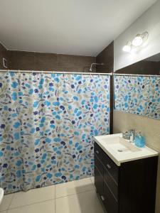 a bathroom with a shower curtain with a sink at Dos D Point "pleno centro" in Río Tercero +9 photos