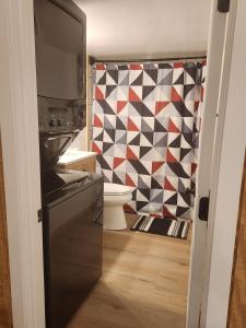a kitchen with a black stove and a geometric shower curtain at Serenity Cabin - Cozy Mountain retreat near Shenandoah National Park in Luray +34 photos