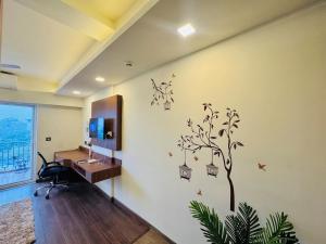 a room with a desk and a tree on the wall at Studio in Dehradun in Dehradun