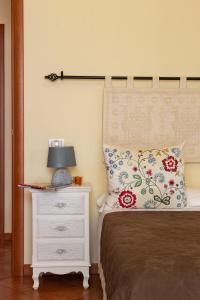 a bedroom with a bed and a lamp on a nightstand at Noelia guesthouse in Bosa