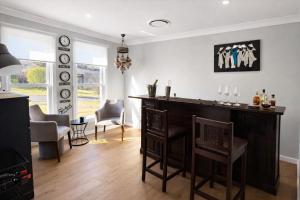 a living room with a bar and some chairs at Time2Reflect - the most relaxing Bowral getaway! in Bowral +12 photos