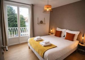 a bedroom with a large bed with two towels on it at White House Dhavernas - Résidence Privée - Amiens - Parking Gratuit in Amiens