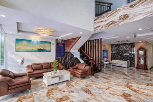 a lobby with leather furniture and a staircase at Xavia Hotel in Quy Nhon