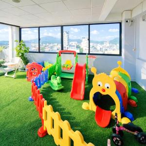 a play room with green grass and toys on the floor at Xavia Hotel in Quy Nhon