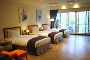 a hotel room with two beds and a large window at 翡秝大飯店 in Beinan