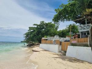a beach with a restaurant and the ocean at White Beach Villa in Dauis