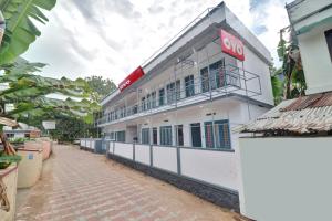 a white building with a red sign on it at Hotel O Skywind in Trivandrum +24 photos