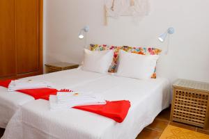 a white bed with red napkins on it at Eira Velha in Portalegre