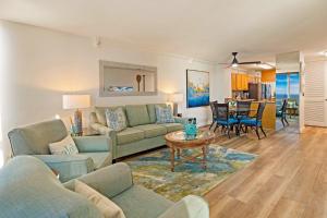 a living room with two couches and a table at Mahana 718 in Lahaina
